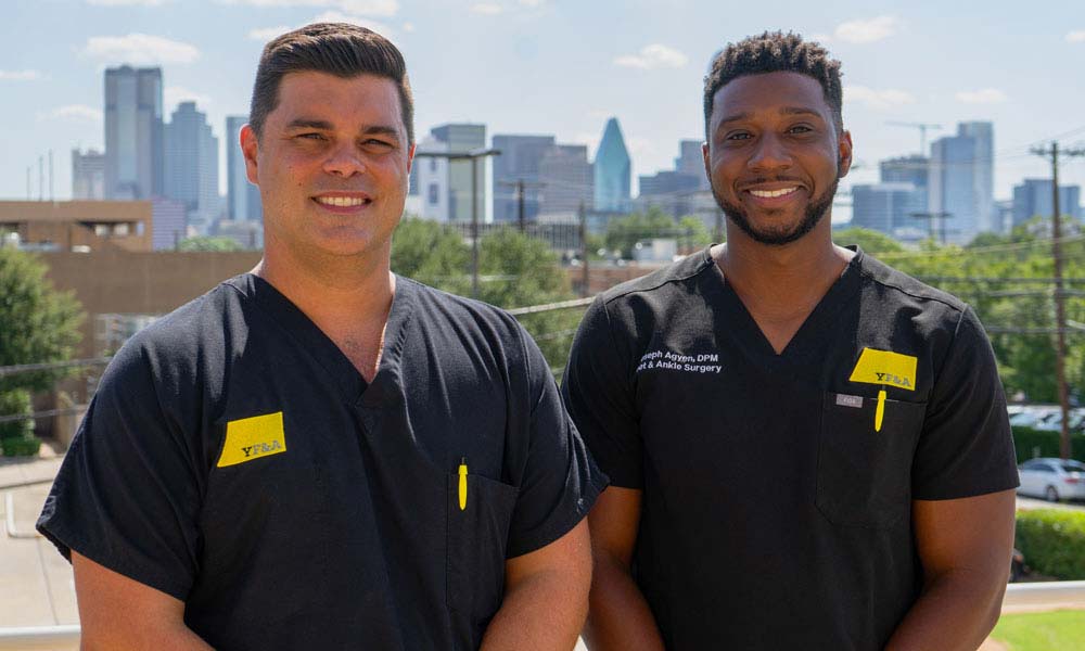 dr-image Dallas Podiatrists Dr. Yeargain and Dr. Agyen posing with the skyline of Dallas, TX in the background